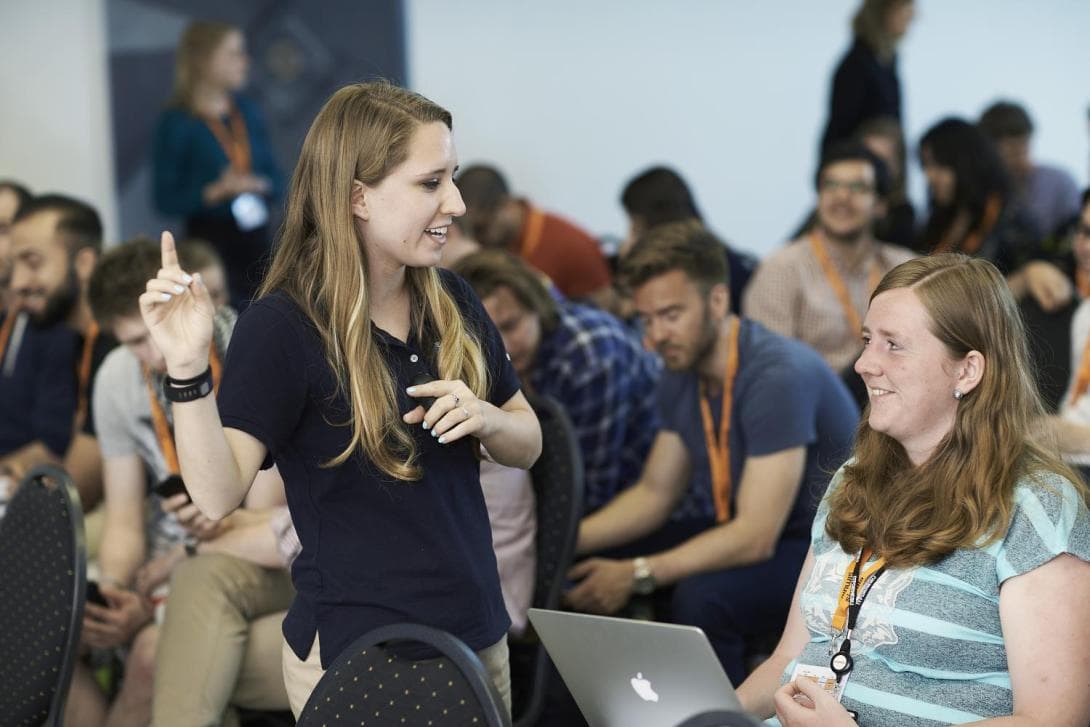 Lecturer talking to a student in front of the class