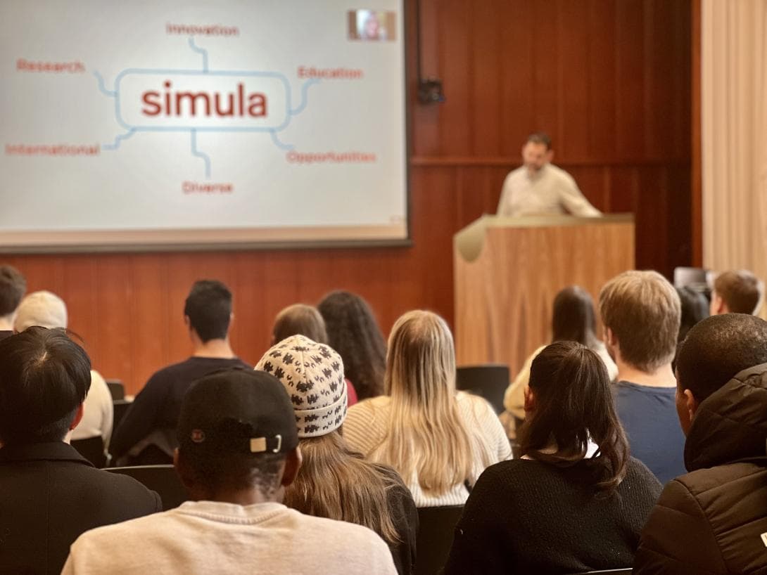 Image of presentation in an auditorium full of students.
